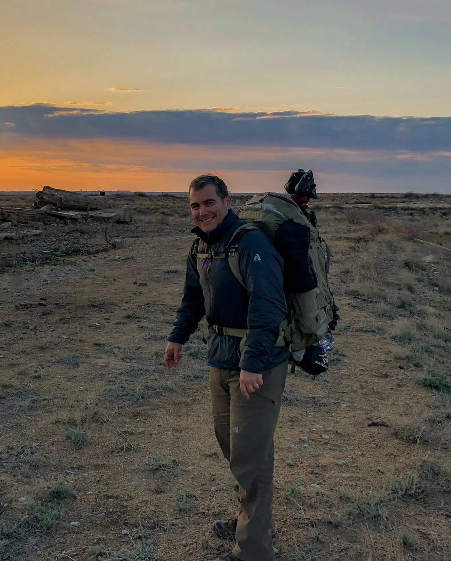 Philip Grossman in the field with camera gear at sunset